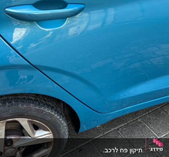 חלק אחורי של רכב כחול עם דלת וידית